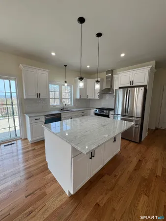 a kitchen with stainless steel appliances granite countertop a sink a stove and a refrigerator