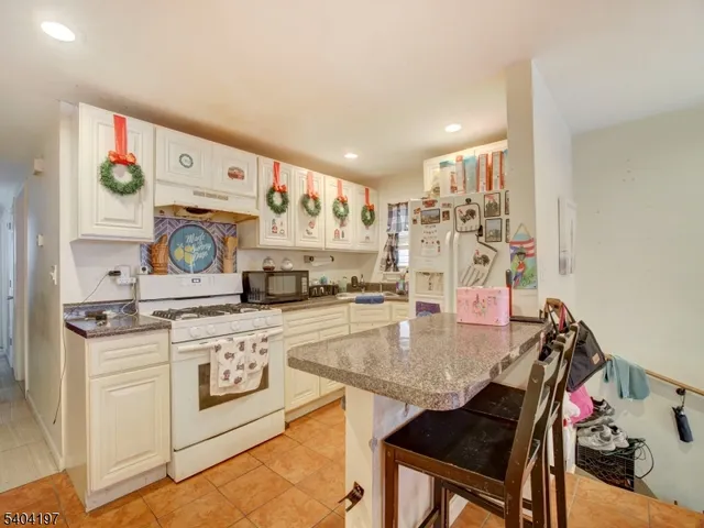 a kitchen with kitchen island a stove a table and chairs in it