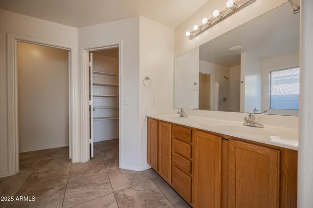 a spacious bathroom with a double vanity sink and a mirror