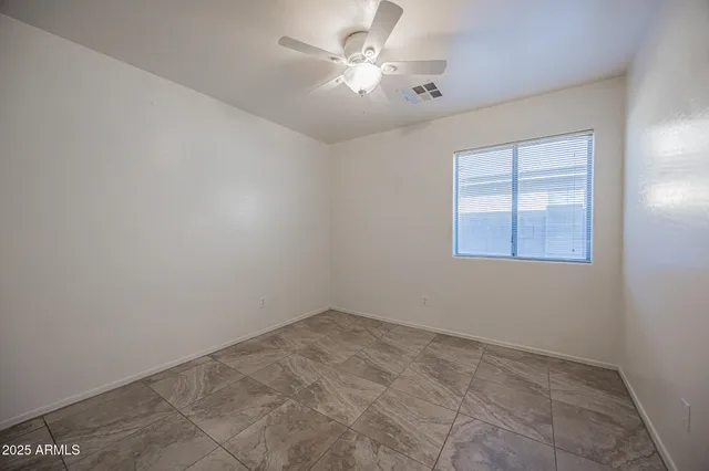 an empty room with windows and fan