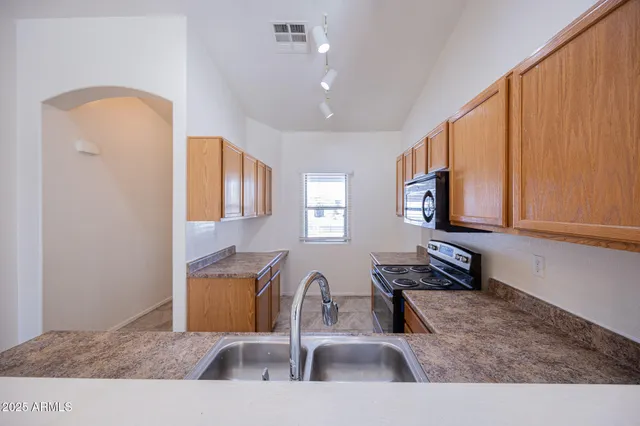 a kitchen with stainless steel appliances granite countertop a sink a stove and a microwave