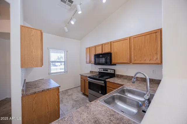 a kitchen with granite countertop a stove a sink and a microwave