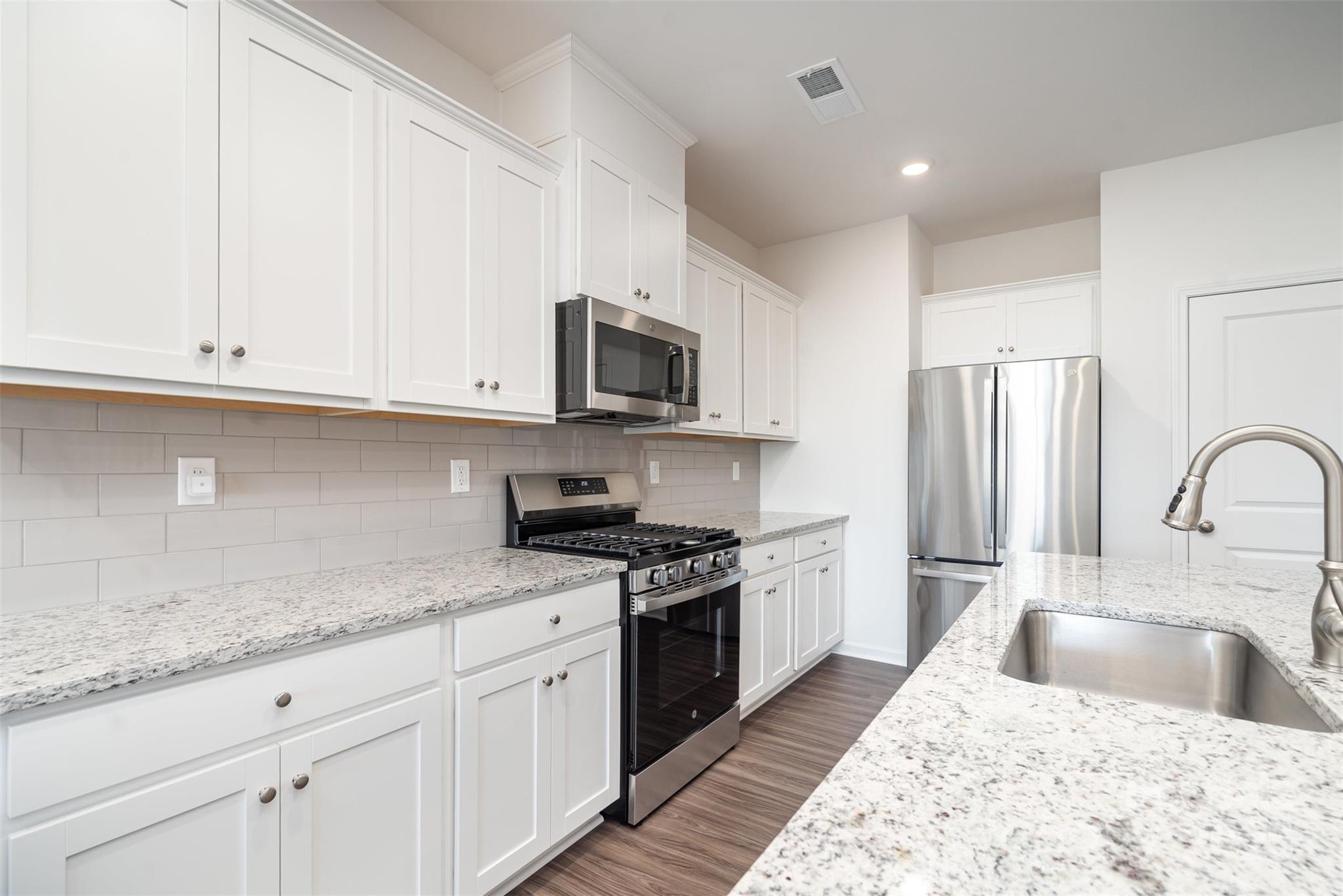 781 Earhart Street Northwest Concord, NC 28027 - Photo 17 of 31 a kitchen with granite countertop white cabinets stainless steel appliances and a sink