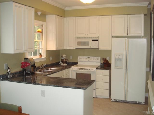 10013 Kilnstone Lane Raleigh, NC 27613 - Photo 3 of 12 a kitchen with a sink a stove and cabinets