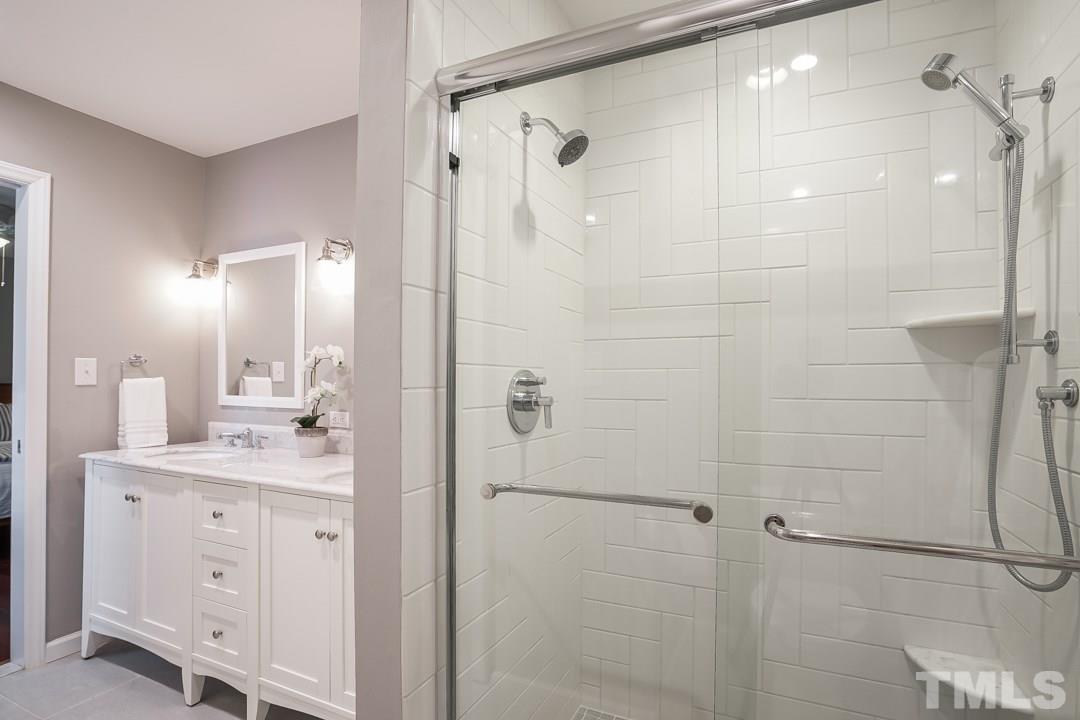 2433 Village Grove Road Raleigh, NC 27613 - Photo 15 of 24 a bathroom with a shower sink and mirror
