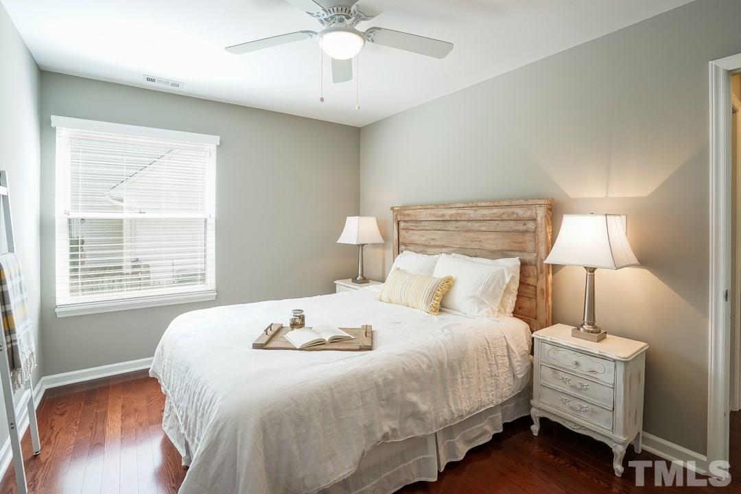2433 Village Grove Road Raleigh, NC 27613 - Photo 19 of 24 a bedroom with a bed and a chandelier