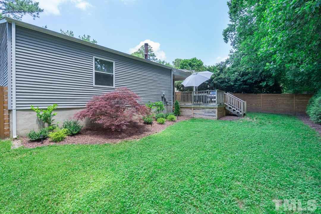 2433 Village Grove Road Raleigh, NC 27613 - Photo 24 of 24 a front view of a house with garden and trees