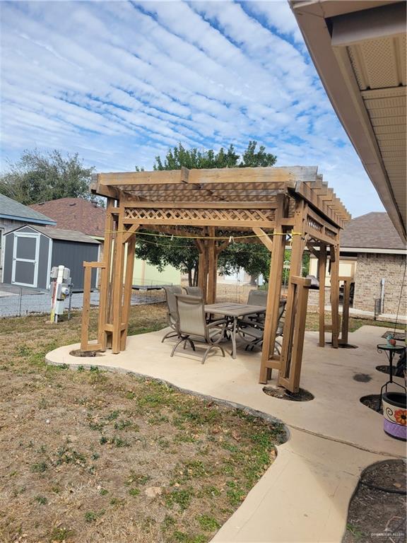 402 Jupiter Street Mission, TX 78572 - Photo 22 of 27 a view of a backyard with table and chairs with wooden floor and fence