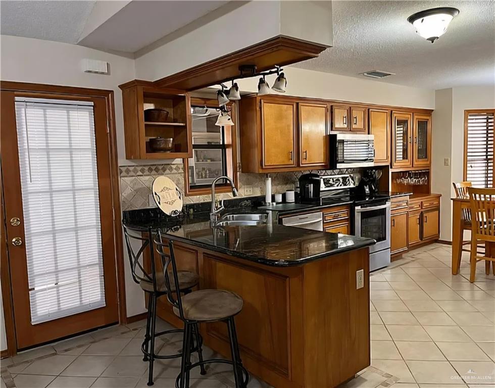 402 Jupiter Street Mission, TX 78572 - Photo 7 of 27 a kitchen with stainless steel appliances granite countertop a sink a stove and a refrigerator