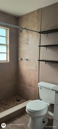 a white toilet sitting next to a bath tub and shower