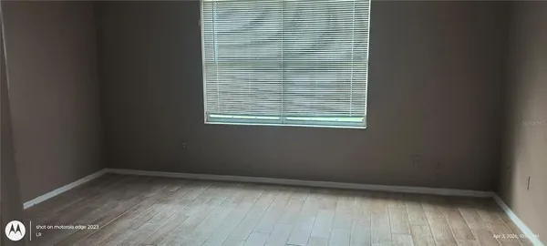 a view of a small space with wooden floor and a window