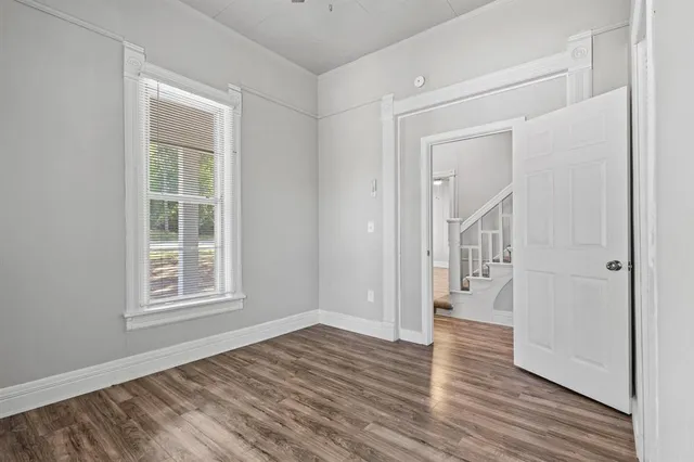 a view of empty room with wooden floor and fan