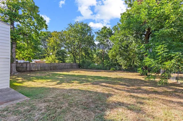 a view of a yard with large trees