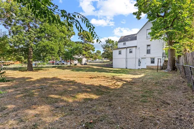 a view of a street with a building and trees in the background