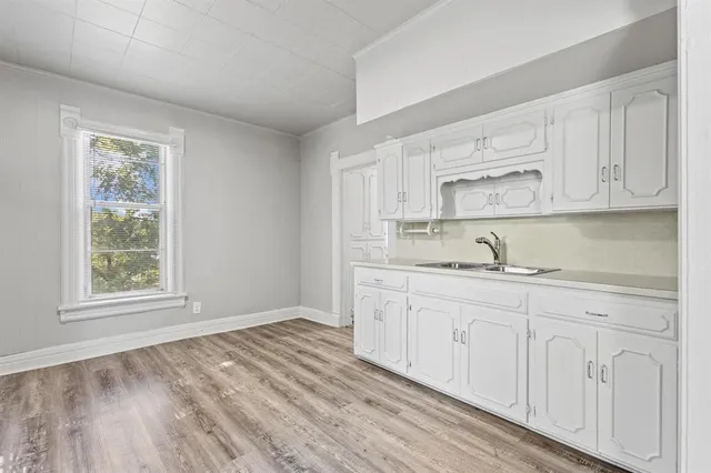 a kitchen with granite countertop white cabinets and a sink