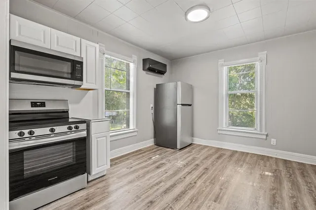 a kitchen with stainless steel appliances a stove microwave and refrigerator