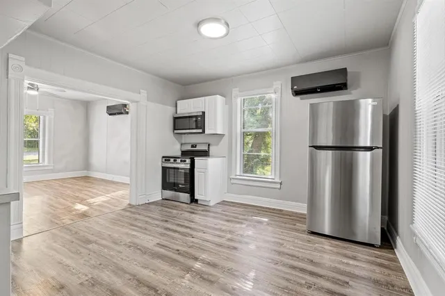 a kitchen with a refrigerator a stove and a wooden floor