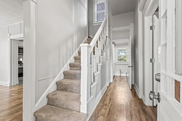 a view of a hallway with wooden floor and staircase