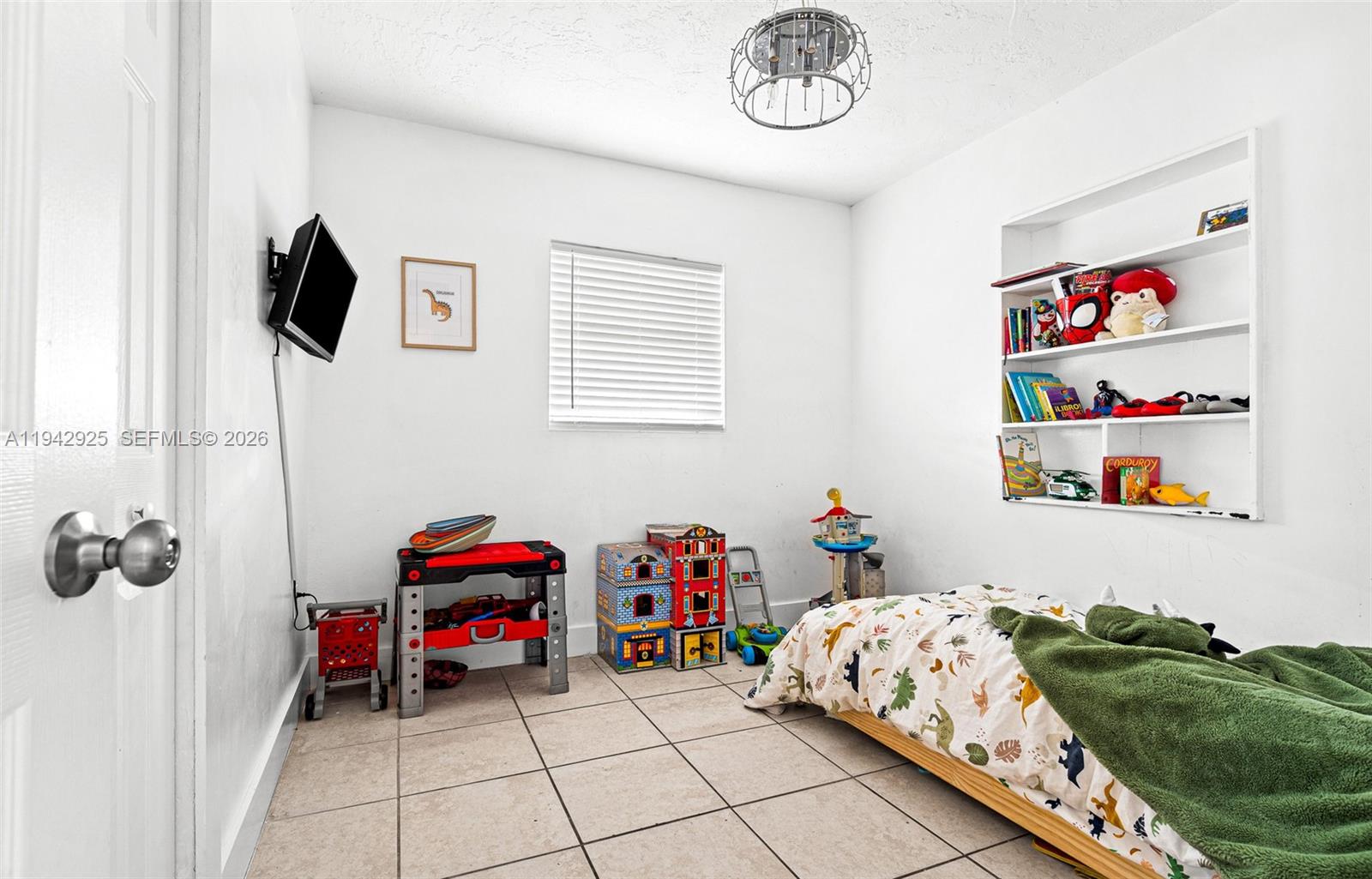 5844 Garfield Street Hollywood, FL 33021 - Photo 15 of 31 a bedroom with a bed and a chandelier