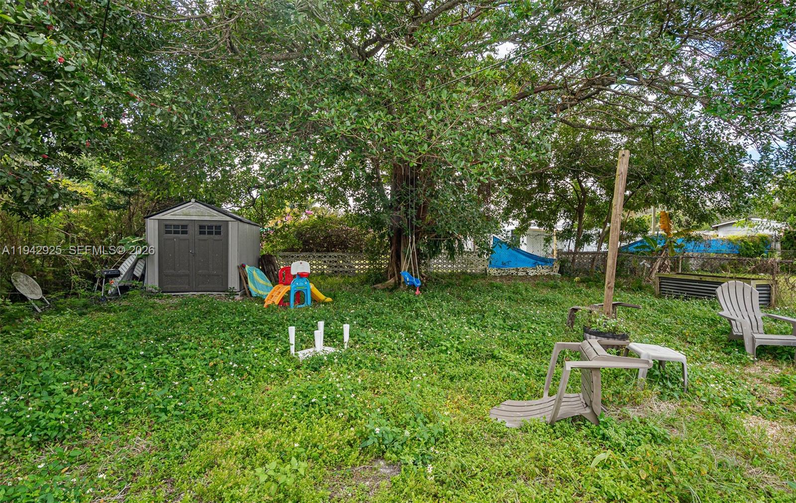 5844 Garfield Street Hollywood, FL 33021 - Photo 30 of 31 a view of a house with a backyard and a tree