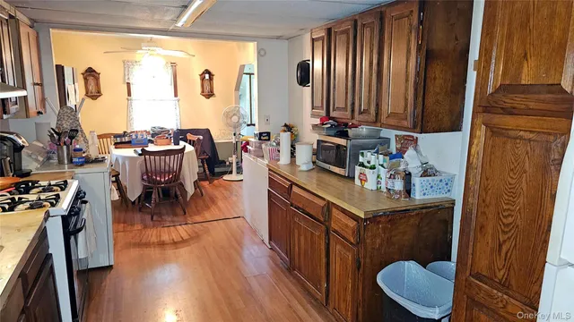a kitchen with stainless steel appliances granite countertop a stove a refrigerator a sink dishwasher with a dining table and chair with wooden floor