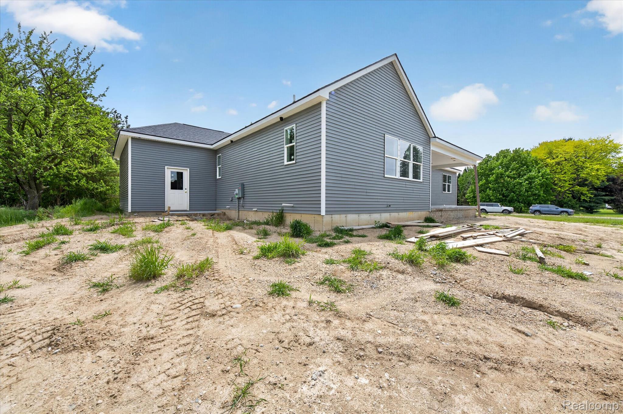 3297 Oak Grove Road Howell, MI 48855 - Photo 23 of 40 Rear exterior showcasing maintenance-free siding and private lot setting.