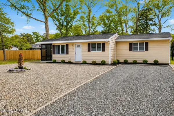 a front view of house with yard and trees in the background