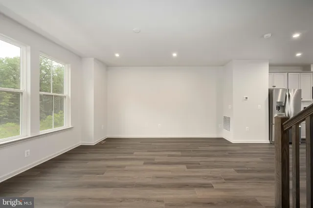 a kitchen with stainless steel appliances granite countertop a sink dishwasher a stove and a refrigerator with wooden floor