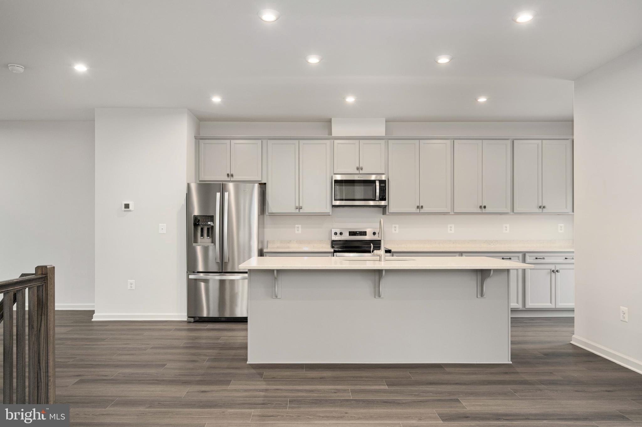 10114 Queens Way Manassas, VA 20110 - Photo 20 of 56 a kitchen with stainless steel appliances granite countertop a refrigerator a stove top oven a sink and dishwasher with wooden floor