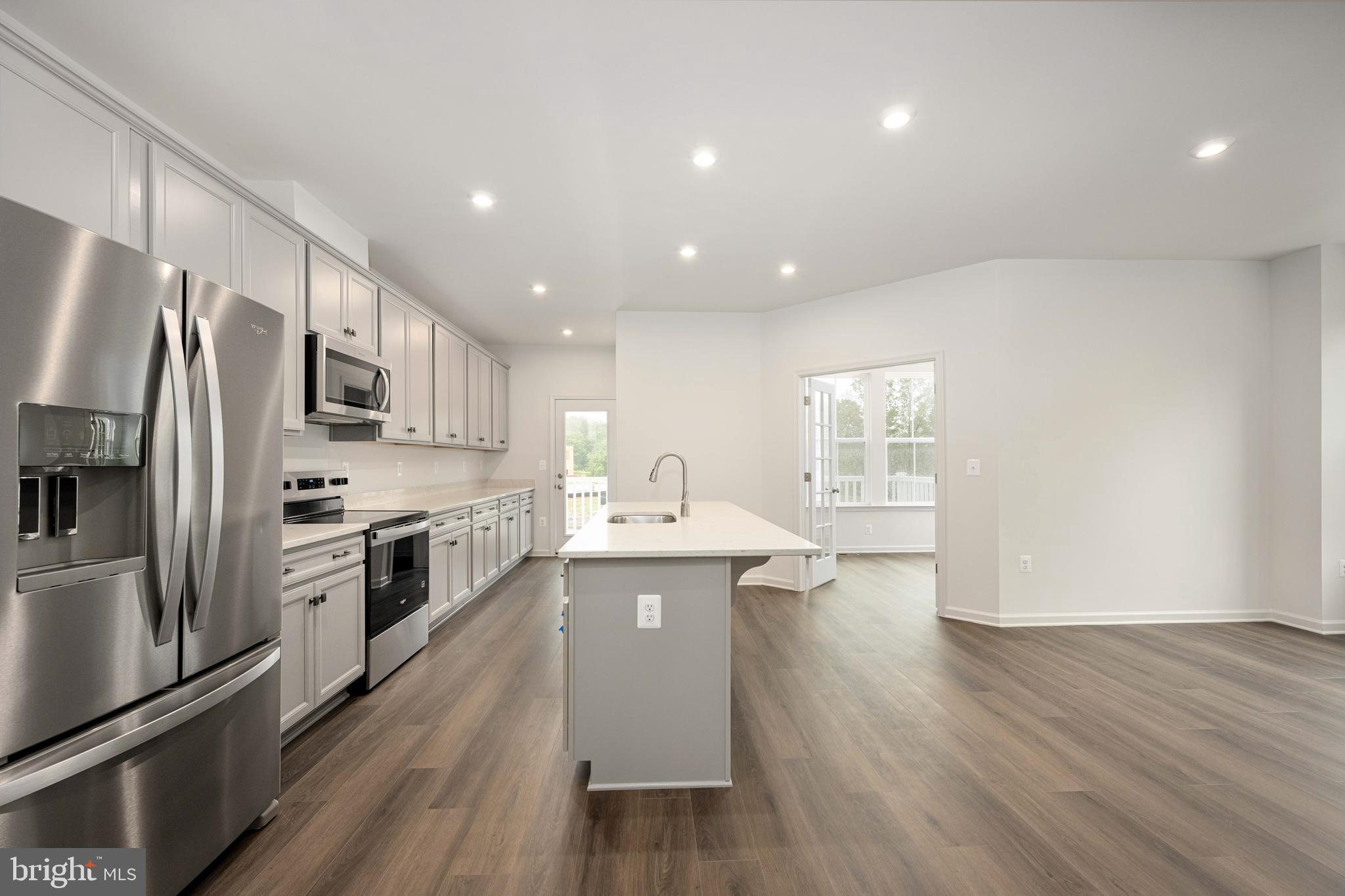 10114 Queens Way Manassas, VA 20110 - Photo 22 of 56 a kitchen with stainless steel appliances granite countertop a refrigerator a sink dishwasher a stove and white countertops with wooden floor