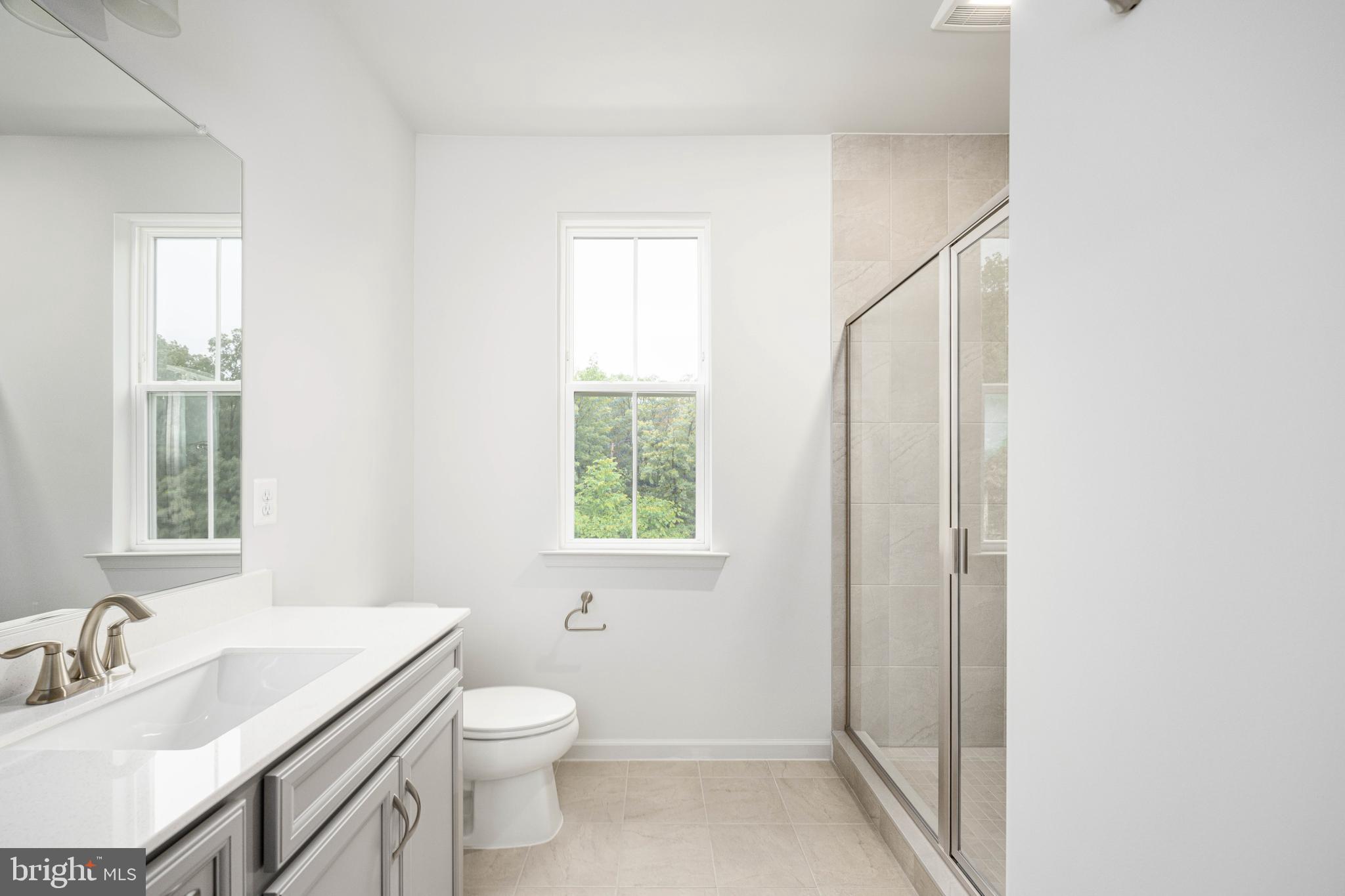 10114 Queens Way Manassas, VA 20110 - Photo 49 of 56 a bathroom with a toilet a sink a mirror and a window