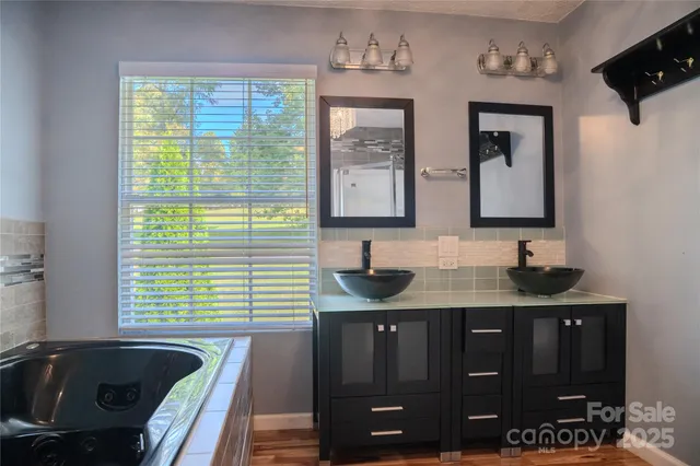 a bathroom with double vanity and a bathtub
