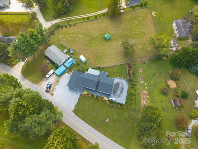an aerial view of a house with a yard swimming pool and outdoor seating