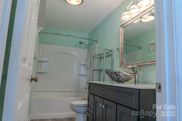 a bathroom with a granite countertop bathtub shower and toilet