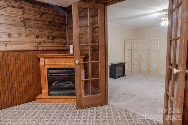 a view of an empty room with chandelier fan