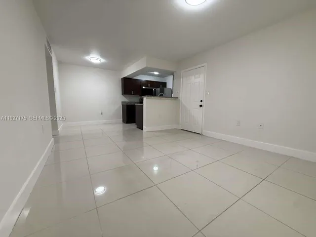 a view of an empty room with kitchen