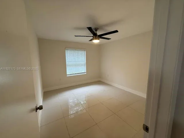an empty room with a ceiling fan and a window