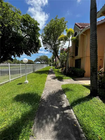 a view of a park with a house in the background