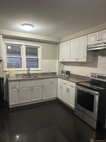 a kitchen with granite countertop white cabinets and white appliances