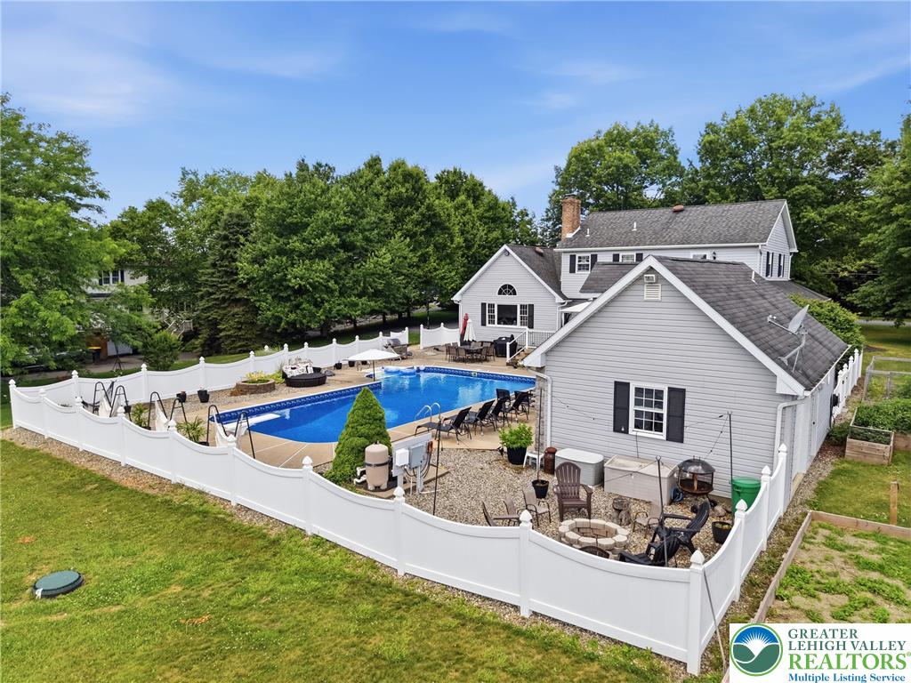 890 Lahr Road Nazareth, PA 18064 - Photo 53 of 71 A spacious outdoor oasis showcases a private pool, fire pit, and ample entertaining space, encircled by a pristine fence.