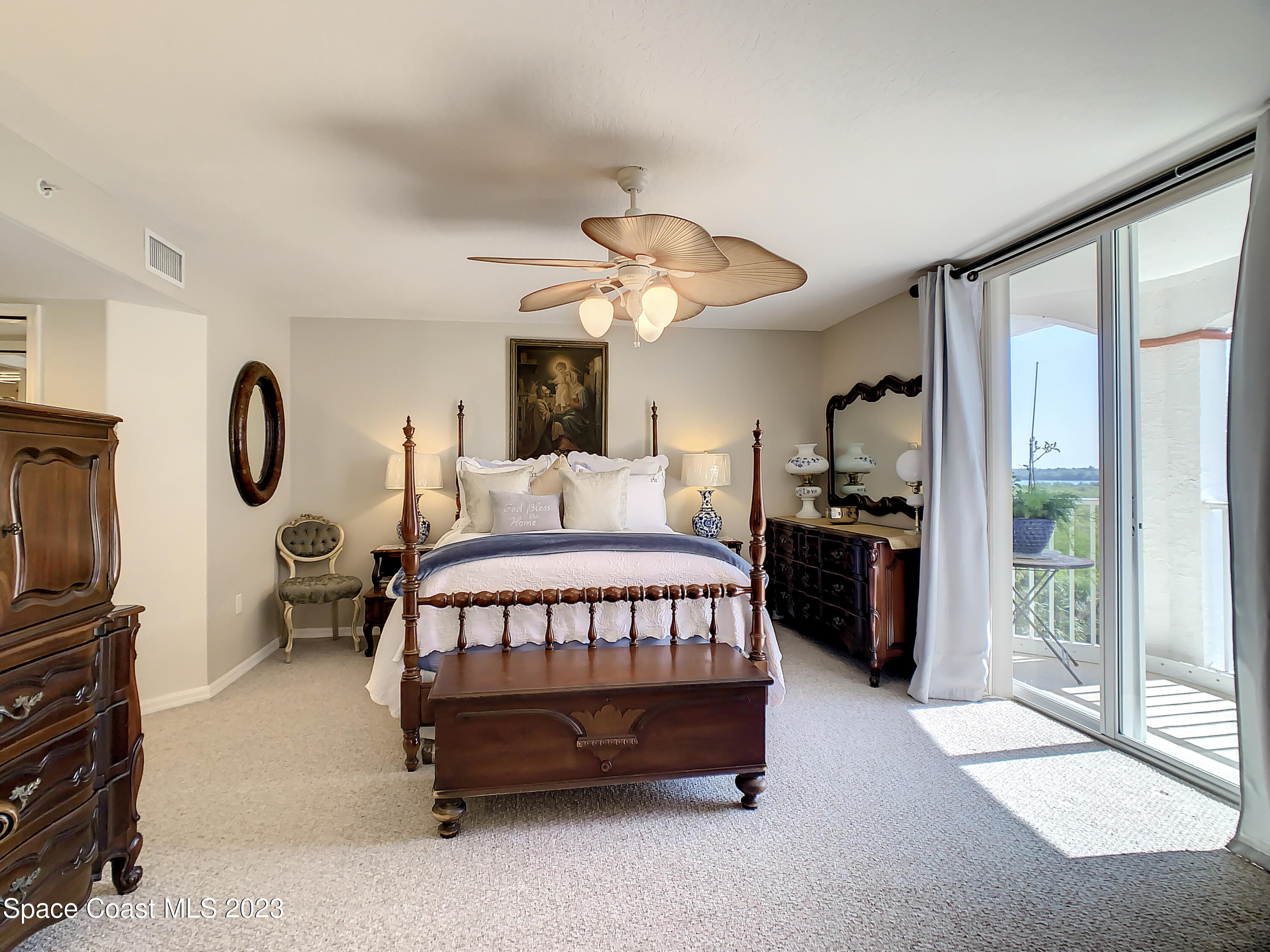 821 Del Rio Way, Unit 504 Merritt Island, FL 32953 - Photo 15 of 37 a bedroom with a bed next to a window with a flat tv screen and dresser