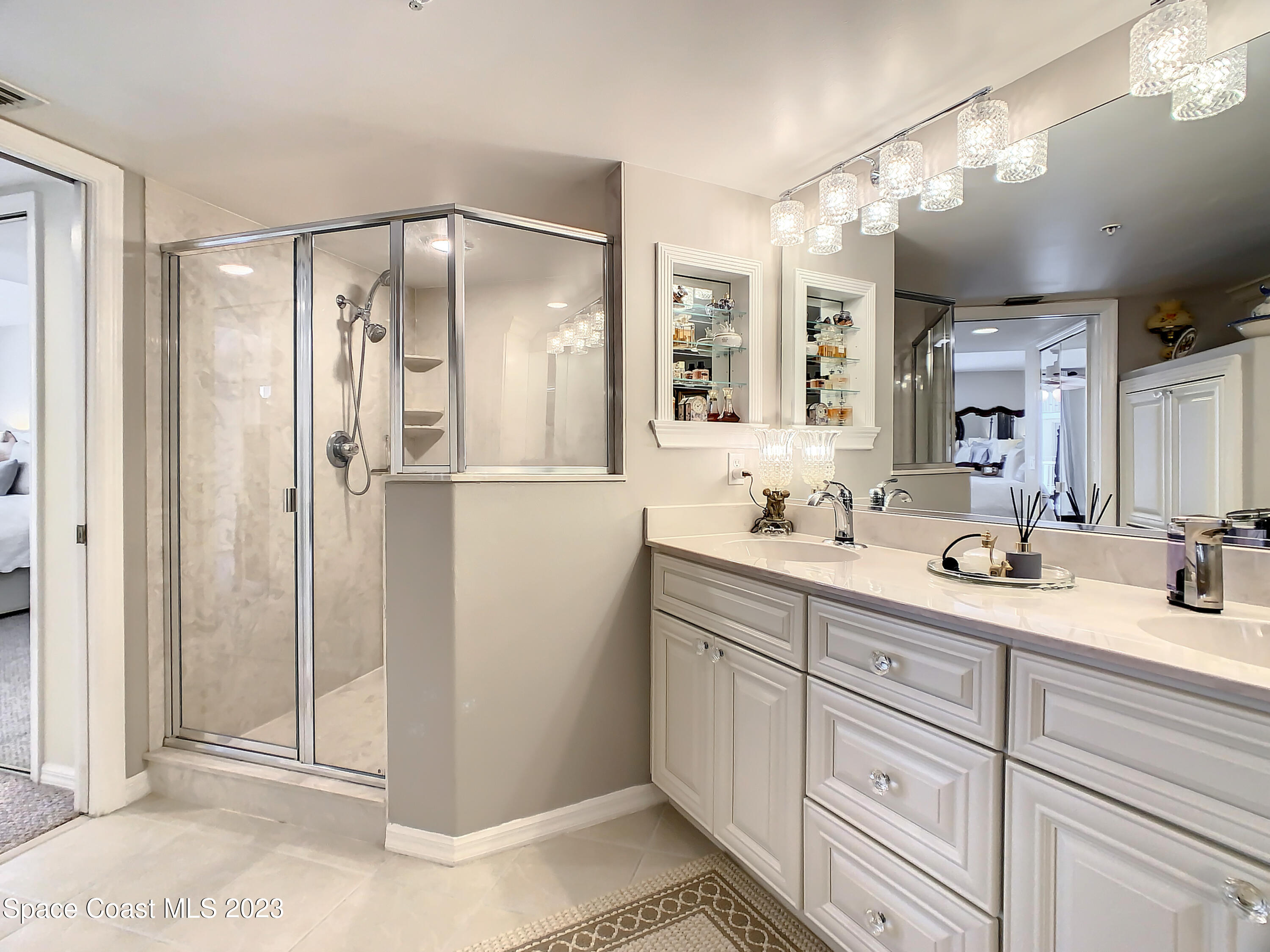 821 Del Rio Way, Unit 504 Merritt Island, FL 32953 - Photo 18 of 37 a bathroom with a double vanity sink mirror and shower