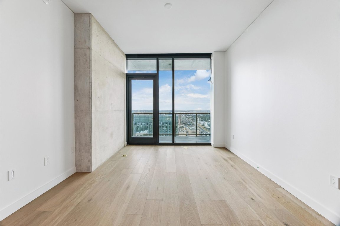 610 Davis Street, Unit 4305 Austin, TX 78701 - Photo 5 of 24 an empty room with wooden floor and windows