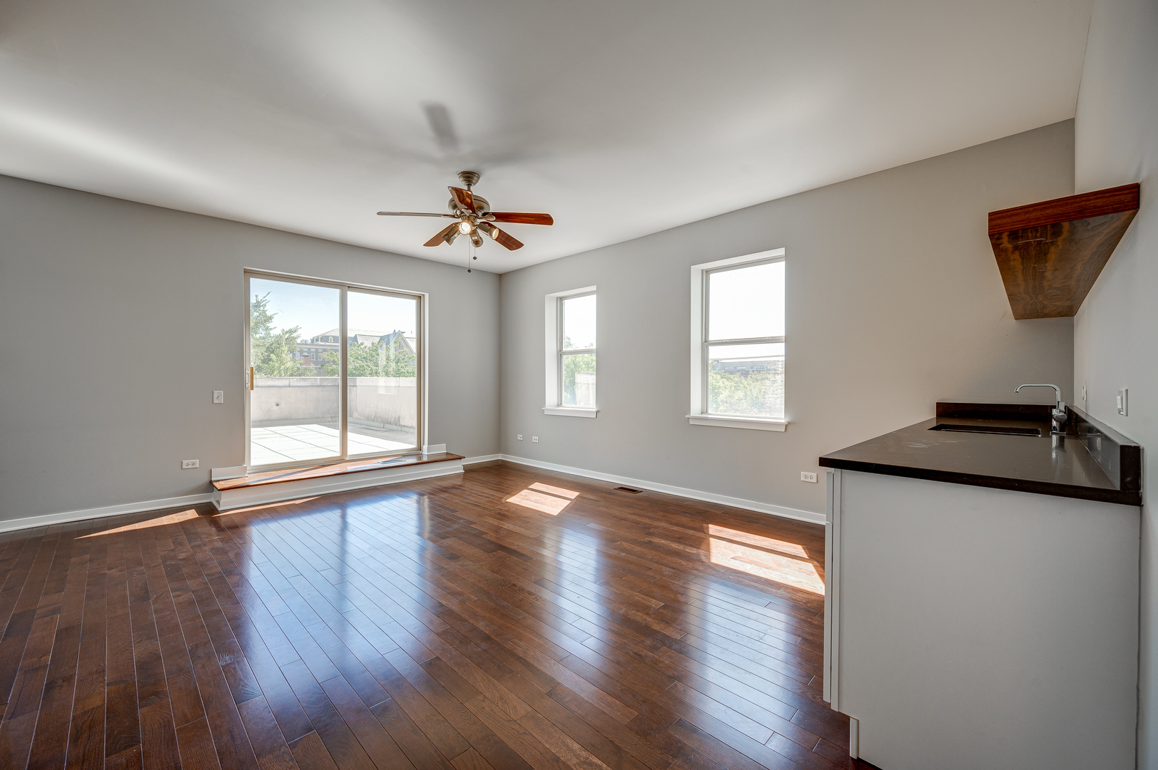 1038 South Racine Avenue, Unit 301 Chicago, IL 60607 - Photo 18 of 24 a view of a livingroom with wooden floor and a ceiling fan