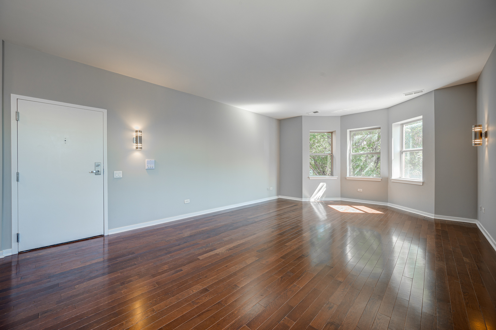 1038 South Racine Avenue, Unit 301 Chicago, IL 60607 - Photo 3 of 24 an empty room with wooden floor and windows