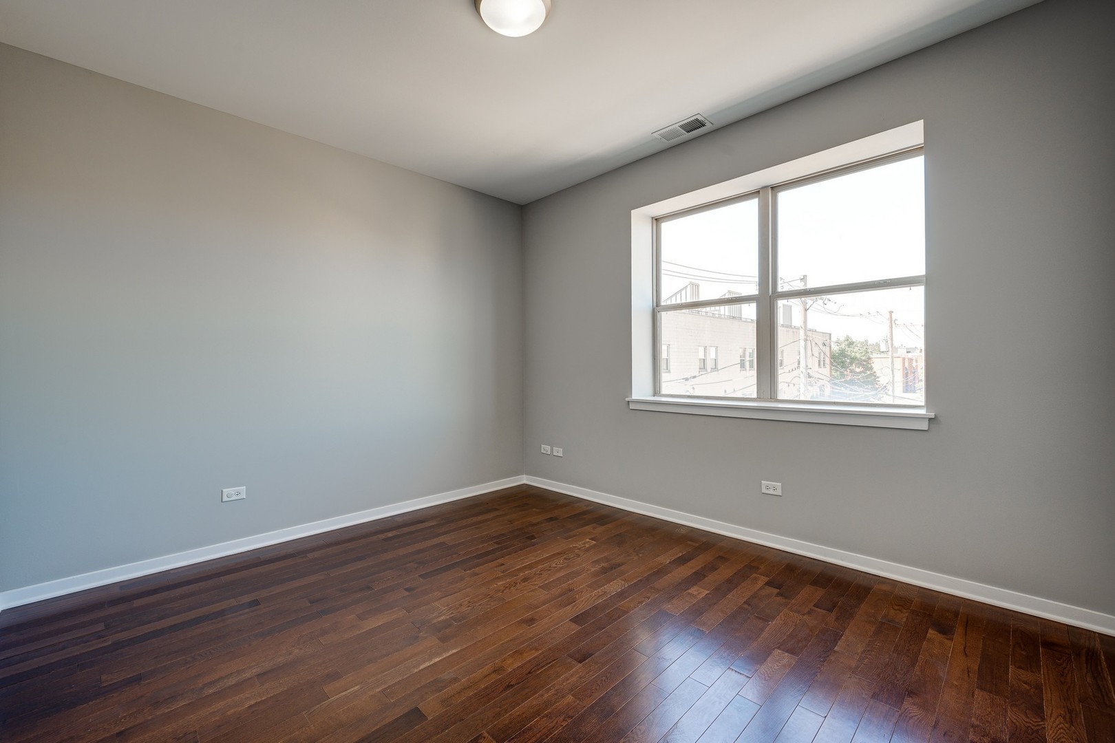 1038 South Racine Avenue, Unit 301 Chicago, IL 60607 - Photo 22 of 24 a view of an empty room with wooden floor and a window