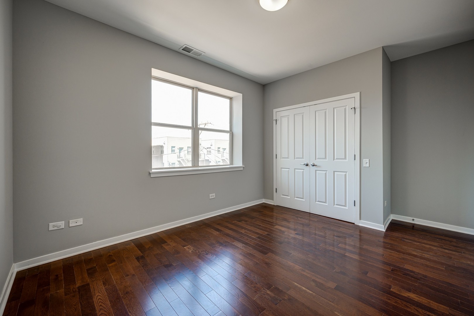 1038 South Racine Avenue, Unit 301 Chicago, IL 60607 - Photo 23 of 24 a view of an empty room with wooden floor and a window