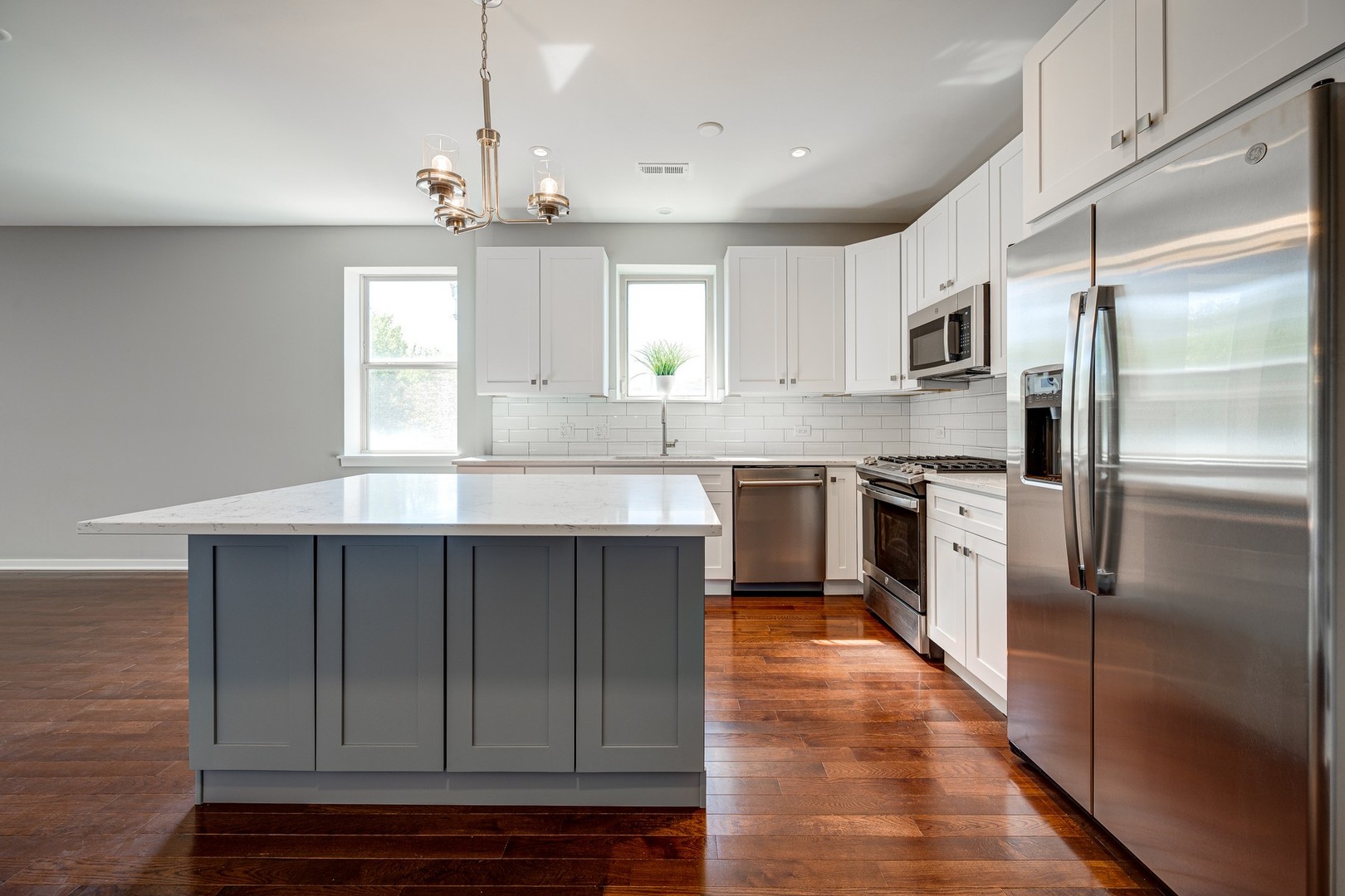 1038 South Racine Avenue, Unit 301 Chicago, IL 60607 - Photo 7 of 24 a kitchen with kitchen island granite countertop a sink cabinets stainless steel appliances and a window