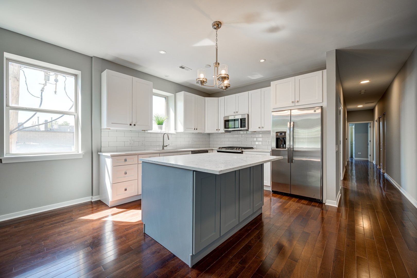 1038 South Racine Avenue, Unit 301 Chicago, IL 60607 - Photo 8 of 24 a kitchen with stainless steel appliances granite countertop a refrigerator a sink dishwasher a stove and white countertops with wooden floor