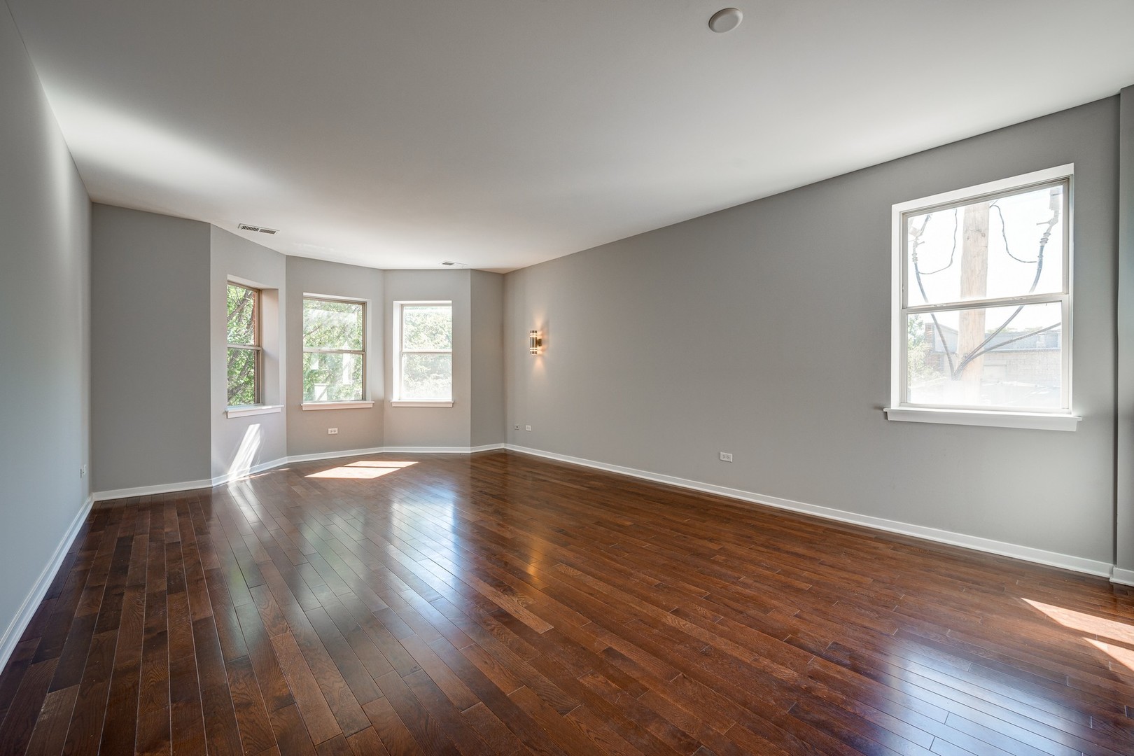 1038 South Racine Avenue, Unit 301 Chicago, IL 60607 - Photo 10 of 24 a view of an empty room with wooden floor and a window